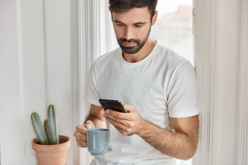 Un habitant lit sur son téléphone le SMS envoyé par sa mairie