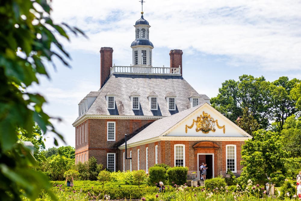 A historic municipal building surrounded by gardens