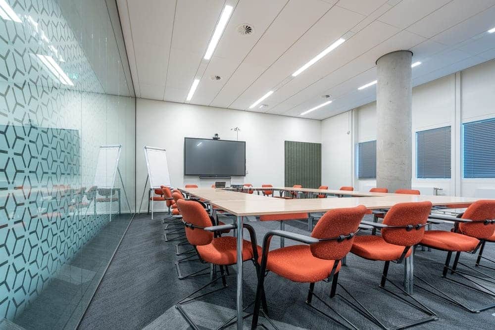 A municipal meeting room fitted with a screen, ready to be booked