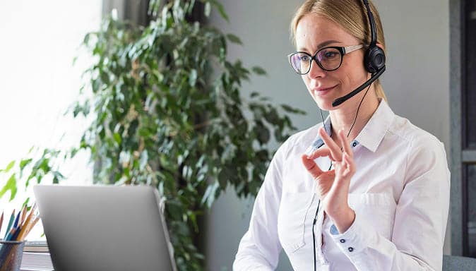 Une agente d’accueil équipée d’un casque confirme un rendez-vous